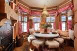 This cozy cabin dining area features a round table surrounded by fur-covered stools, perfect for intimate gatherings.