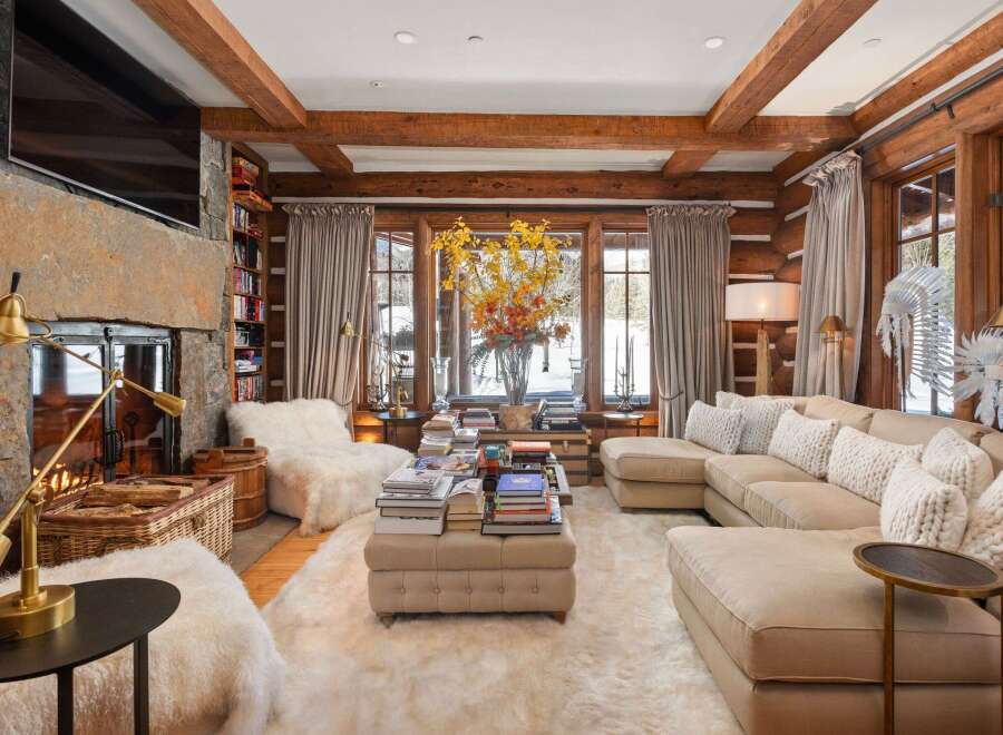 Step into luxury with this stunning living room, featuring a cozy fireplace and a plush, inviting sofa.