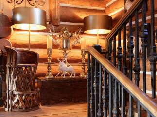 Step into rustic elegance with this stunning property, showcasing a beautifully crafted wooden staircase and warm, inviting log walls.