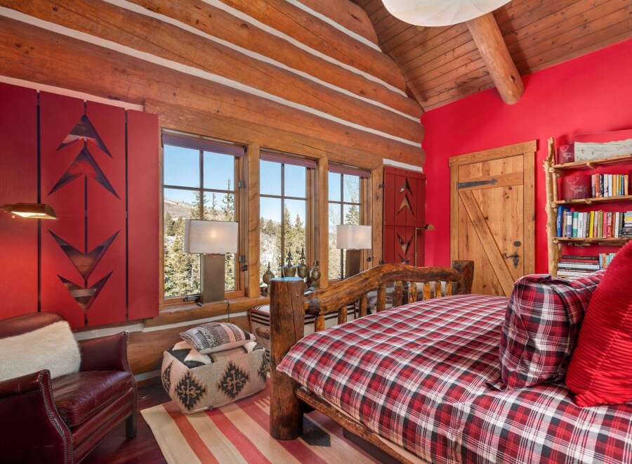 This cozy bedroom features a rustic log bed frame and matching wooden accents, creating a warm and inviting atmosphere.