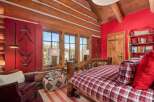 This cozy bedroom features a rustic log bed frame and matching wooden accents, creating a warm and inviting atmosphere.