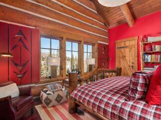 This cozy bedroom features a rustic log bed frame and matching wooden accents, creating a warm and inviting atmosphere.