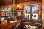 This rustic bathroom exudes warmth and charm with its log cabin aesthetic.