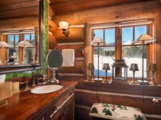 This rustic bathroom exudes warmth and charm with its log cabin aesthetic.