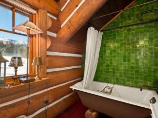 This rustic bathroom features a charming log cabin aesthetic, perfect for a cozy retreat.