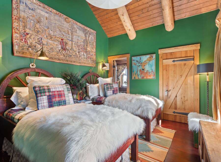 Step into rustic elegance with this charming bedroom, featuring twin beds adorned with plush faux fur throws and plaid accents.