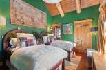 Step into rustic elegance with this charming bedroom, featuring twin beds adorned with plush faux fur throws and plaid accents.