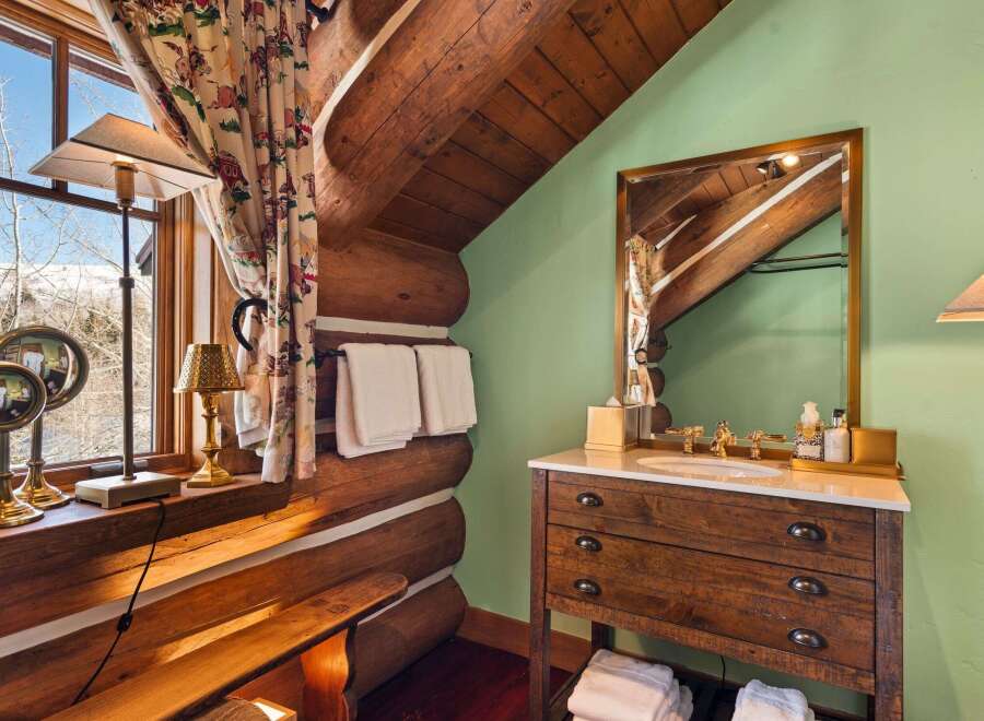 This rustic bathroom features a charming log cabin aesthetic, perfect for a cozy retreat.