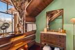 This rustic bathroom features a charming log cabin aesthetic, perfect for a cozy retreat.