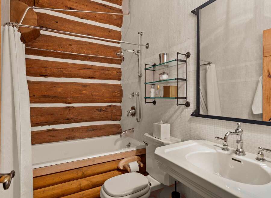 This stunning bathroom boasts a rustic charm with its log cabin-inspired design.
