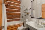 This stunning bathroom boasts a rustic charm with its log cabin-inspired design.