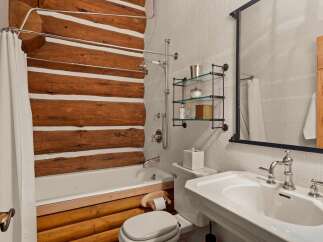 This stunning bathroom boasts a rustic charm with its log cabin-inspired design.