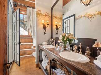 This luxurious bathroom boasts a rustic yet elegant design, perfect for a cozy retreat.