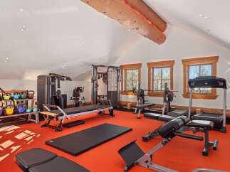 Step into your dream home gym! This space boasts a variety of workout equipment, including weight machines, free weights, and cardio machines, perfect for any fitness enthusiast.