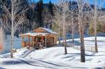 Nestled in a serene winter wonderland, this charming log cabin offers a cozy retreat.