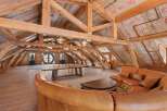 Step into rustic elegance with this stunning loft space, showcasing exposed wooden beams and a warm, inviting atmosphere.