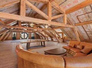 Step into rustic elegance with this stunning loft space, showcasing exposed wooden beams and a warm, inviting atmosphere.