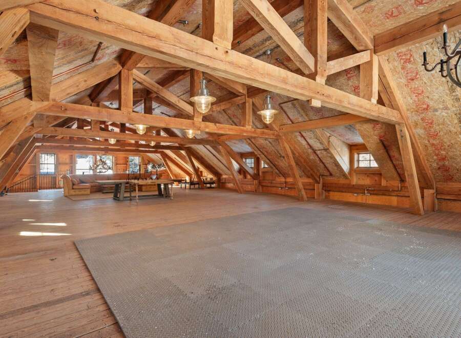 This stunning property boasts a spacious, open-concept interior with exposed wooden beams, creating a warm and inviting atmosphere.