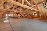 This stunning property boasts a spacious, open-concept interior with exposed wooden beams, creating a warm and inviting atmosphere.