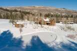 This stunning property boasts a luxurious log cabin nestled in a winter wonderland.