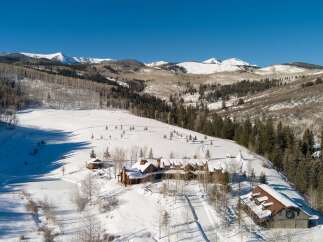 Nestled in a winter wonderland, this stunning property boasts a luxurious lodge-style home with breathtaking mountain views.