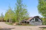 Nestled amidst lush greenery, this stunning property boasts a charming barn-style structure with a rustic aesthetic.