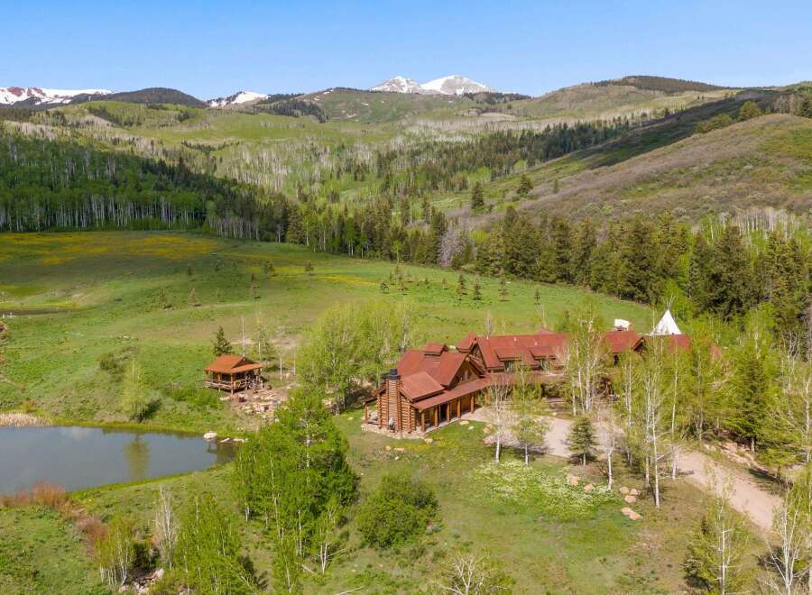 Escape to your dream retreat! This stunning property boasts a luxurious lodge-style home, a charming cabin, and a serene pond, all nestled in a breathtaking mountain landscape.