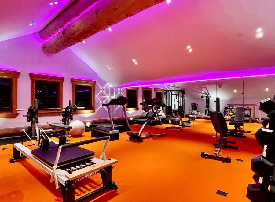 Transform your fitness routine in this state-of-the-art home gym, bathed in vibrant purple lighting.