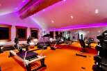 Transform your fitness routine in this state-of-the-art home gym, bathed in vibrant purple lighting.