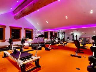 Transform your fitness routine in this state-of-the-art home gym, bathed in vibrant purple lighting.