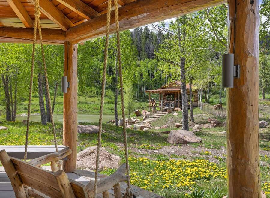 Experience rustic charm with this picturesque log cabin nestled amidst lush greenery and a serene lake.