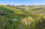 Escape to this stunning mountain retreat featuring multiple charming cabins nestled amidst lush aspen and pine forests.