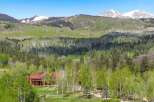 Nestled amidst a vibrant aspen and pine forest, this stunning log home offers a serene mountain retreat.