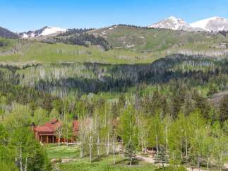 Nestled amidst a vibrant aspen and pine forest, this stunning log home offers a serene mountain retreat.