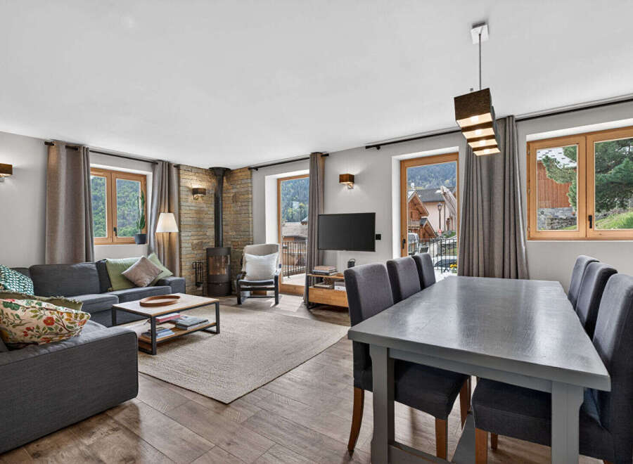 Discover the charm of this stunning property, featuring a cozy living area with a fireplace and a modern dining space.