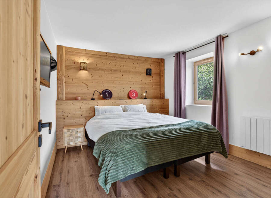 Experience the charm of this cozy bedroom, featuring a rustic wooden headboard that adds warmth and character.