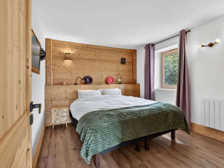 Experience the charm of this cozy bedroom, featuring a rustic wooden headboard that adds warmth and character.