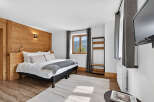 Experience the charm of this cozy bedroom featuring a wooden accent wall and a comfortable bed.