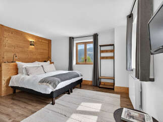 Experience the charm of this cozy bedroom featuring a wooden accent wall and a comfortable bed.