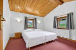 Discover the charm of this cozy bedroom featuring a unique wooden ceiling and a comfortable twin bed setup.