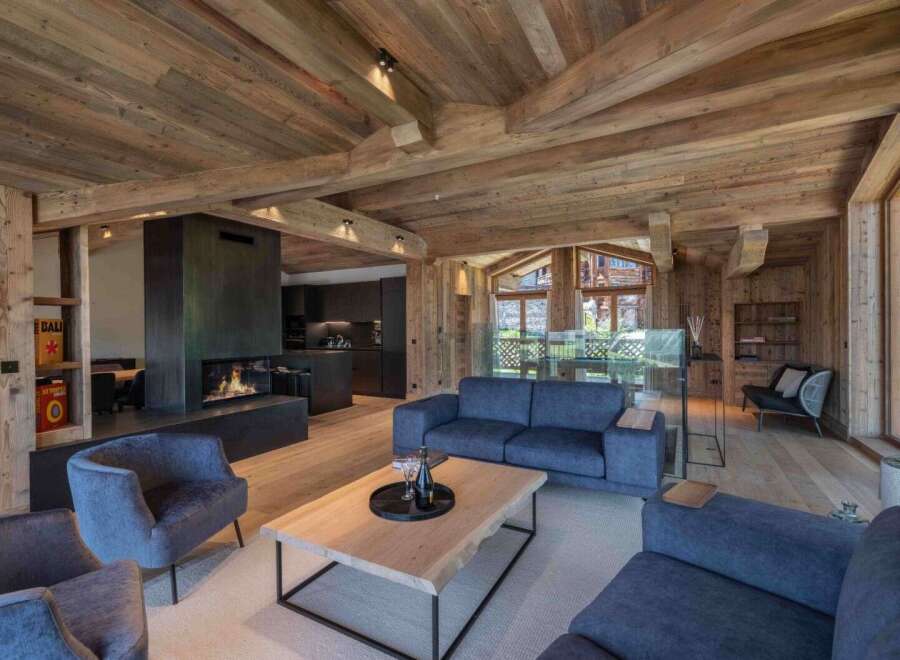 Experience luxury living in this stunning chalet, featuring a cozy fireplace and a modern kitchen.