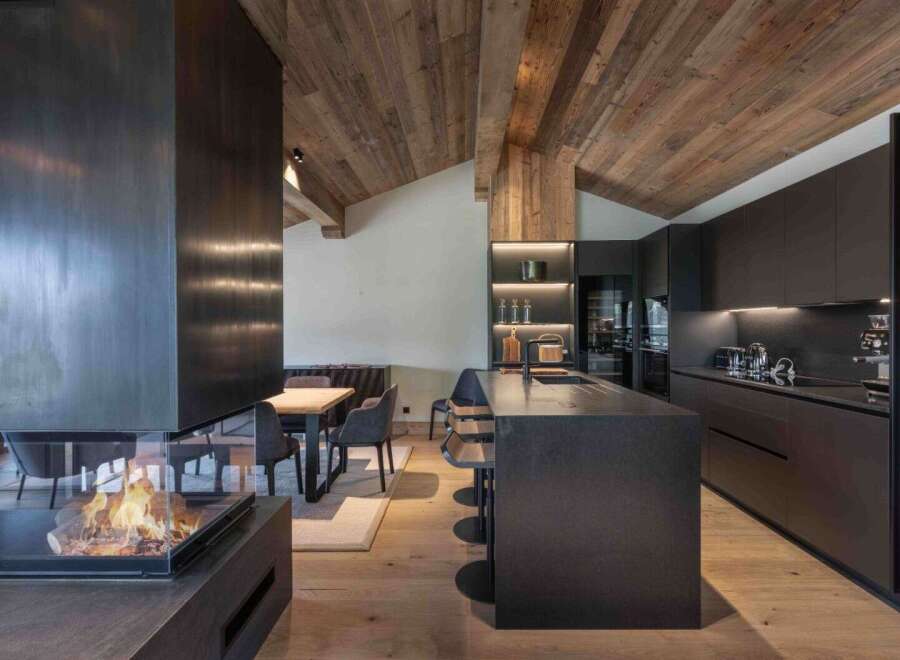 Experience luxury living in this stunning property featuring a modern kitchen with sleek black cabinetry and a spacious island.