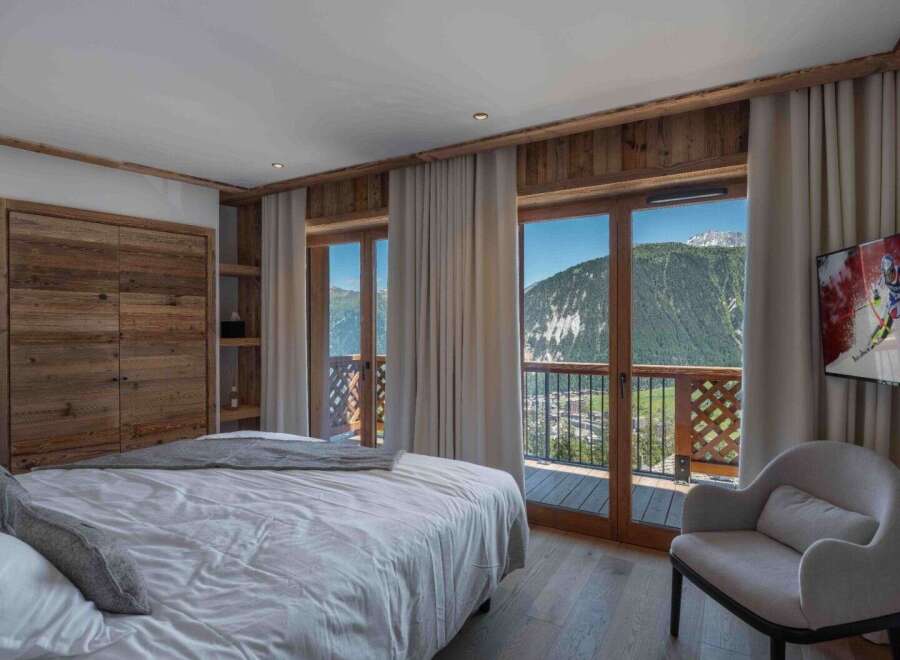 Experience the ultimate in luxury living with this stunning bedroom featuring breathtaking mountain views.