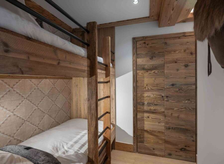 This cozy bedroom features custom-built bunk beds, perfect for accommodating guests or family members.
