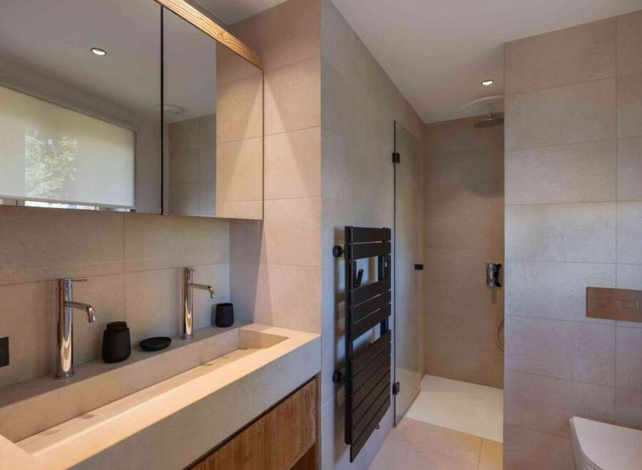 This modern bathroom boasts a sleek design with neutral tones and high-end finishes.