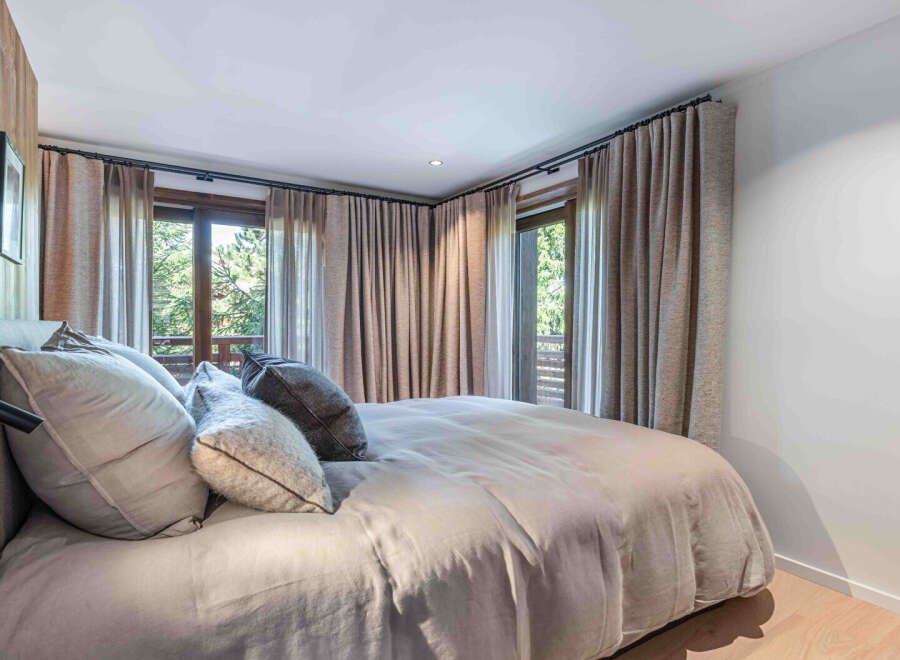Experience tranquility in this elegant bedroom, featuring a serene ambiance and natural light.