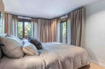 Experience tranquility in this elegant bedroom, featuring a serene ambiance and natural light.