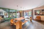 Step into luxury with this stunning dining room, featuring a unique wooden table and built-in seating.