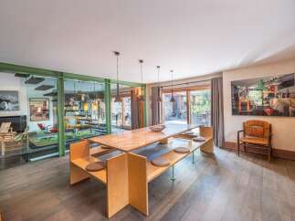 Step into luxury with this stunning dining room, featuring a unique wooden table and built-in seating.