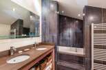 Step into luxury with this stunning bathroom featuring a sleek double vanity and a relaxing soaking tub.